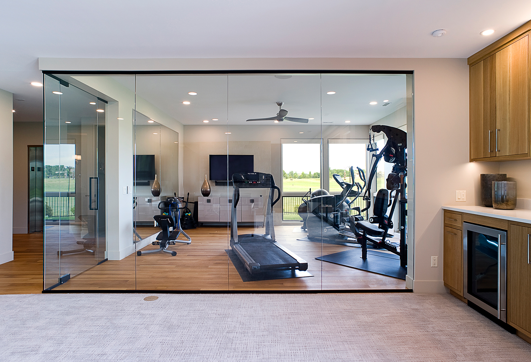 home gym with floor to ceiling windows into the hallway