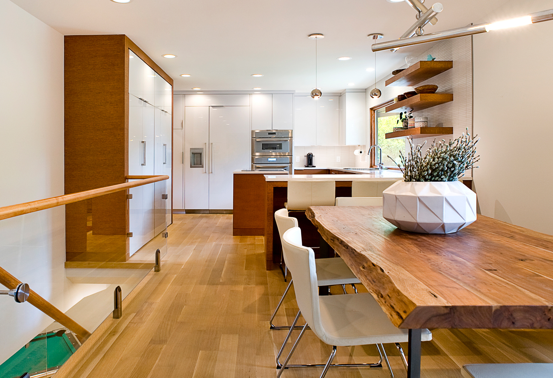 dining table leading into kitchen with modern white seamless cabinets